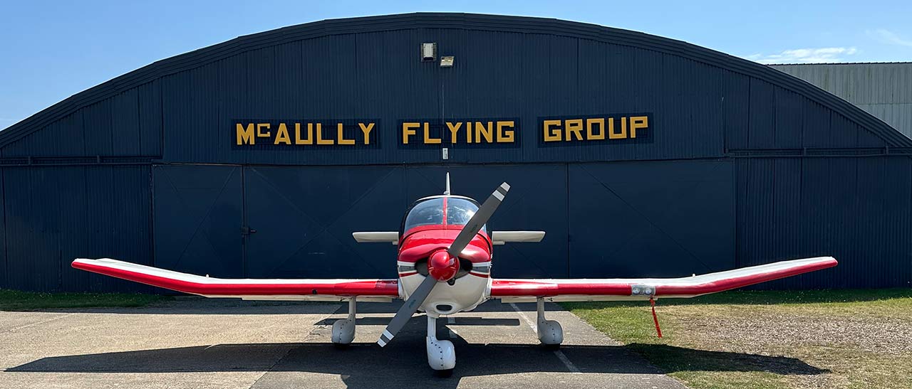 G-NBDD in front of McAully aircraft hangar